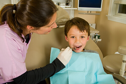 Young boy giving thumbs up in dental chair