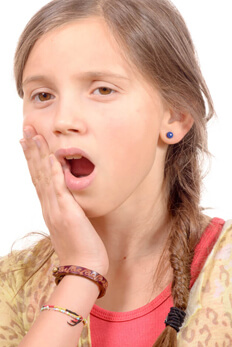 girl holding cheek in pain