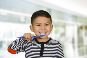 young boy brushing his teeth