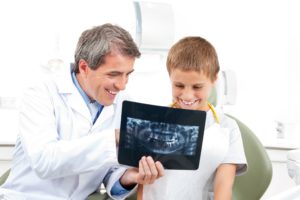 dentist showing child an x-ray