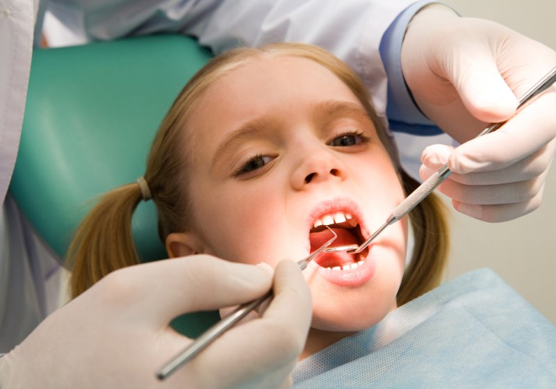 a young girl getting her teeth cleaned