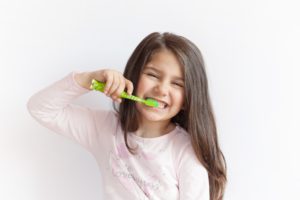 Young girl brushing teeth at pediatric dentist in Northampton. 