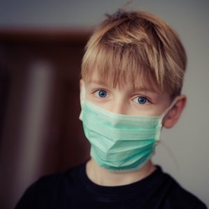 Boy wearing mask at pediatric dentist in Greenfield.