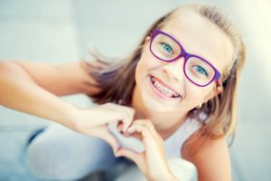 Young girl making a heart with hands